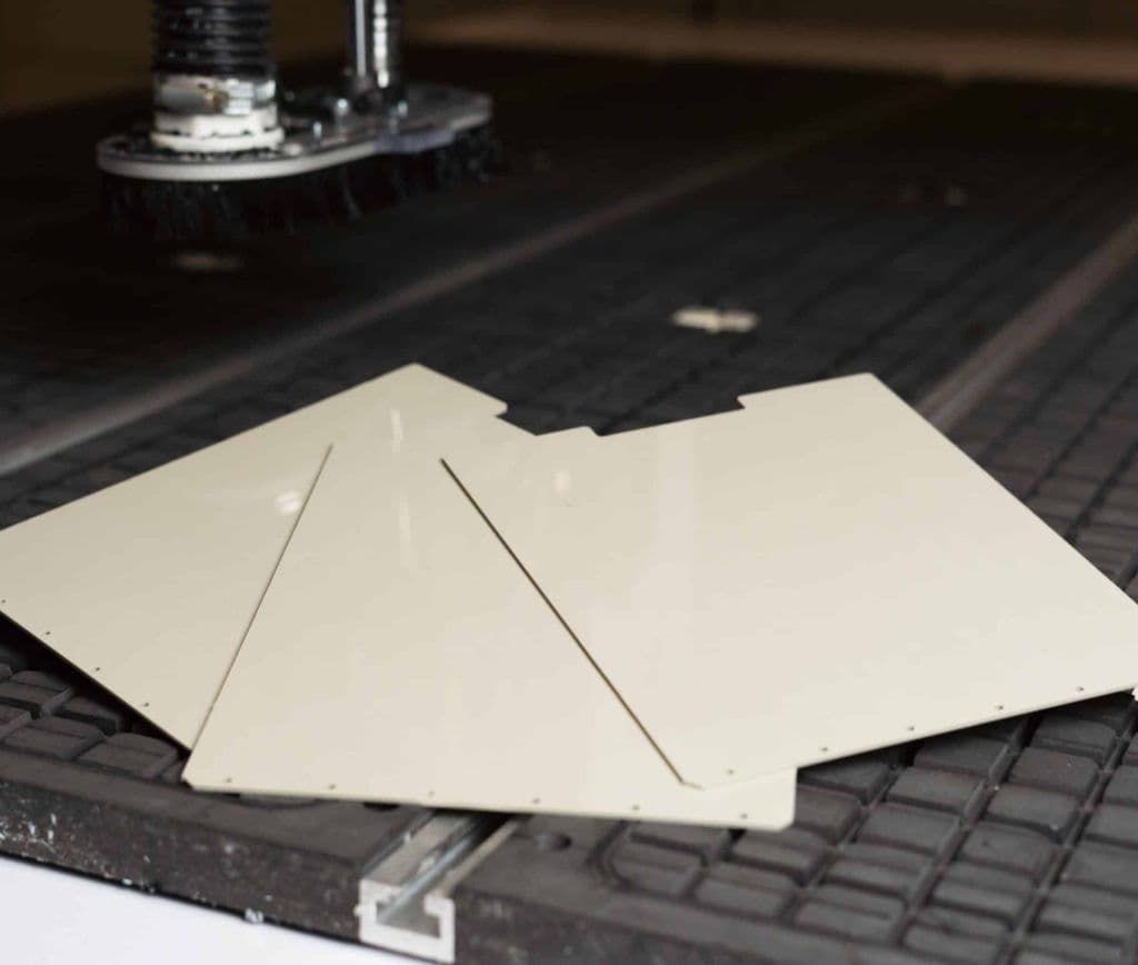 Gefreesde platen van polypropyleen met boorgaten en uitsparingen op de vacuümtafel van de CNC-freesmachine